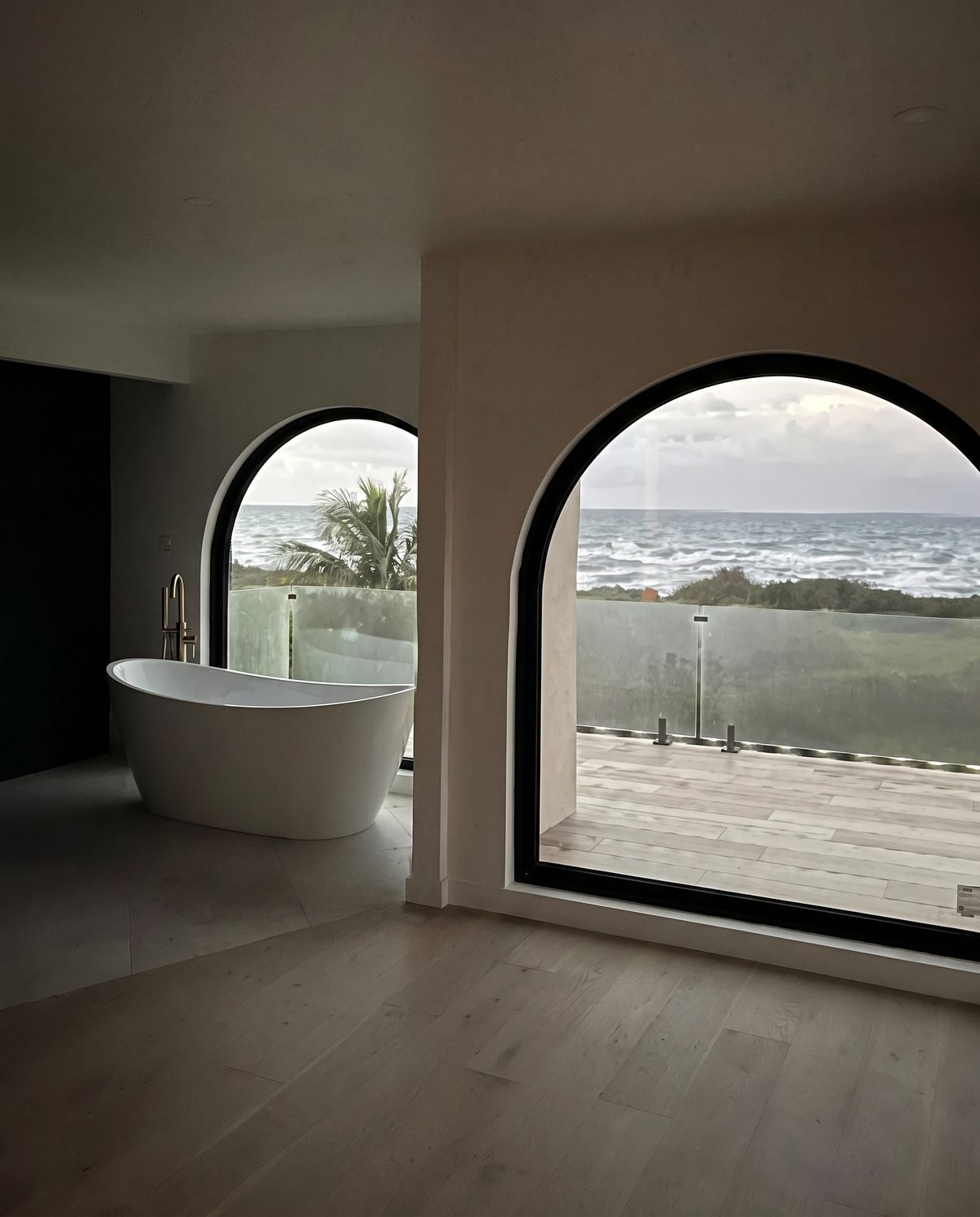 Arched picture windows framing an ocean view in a Maui remodel