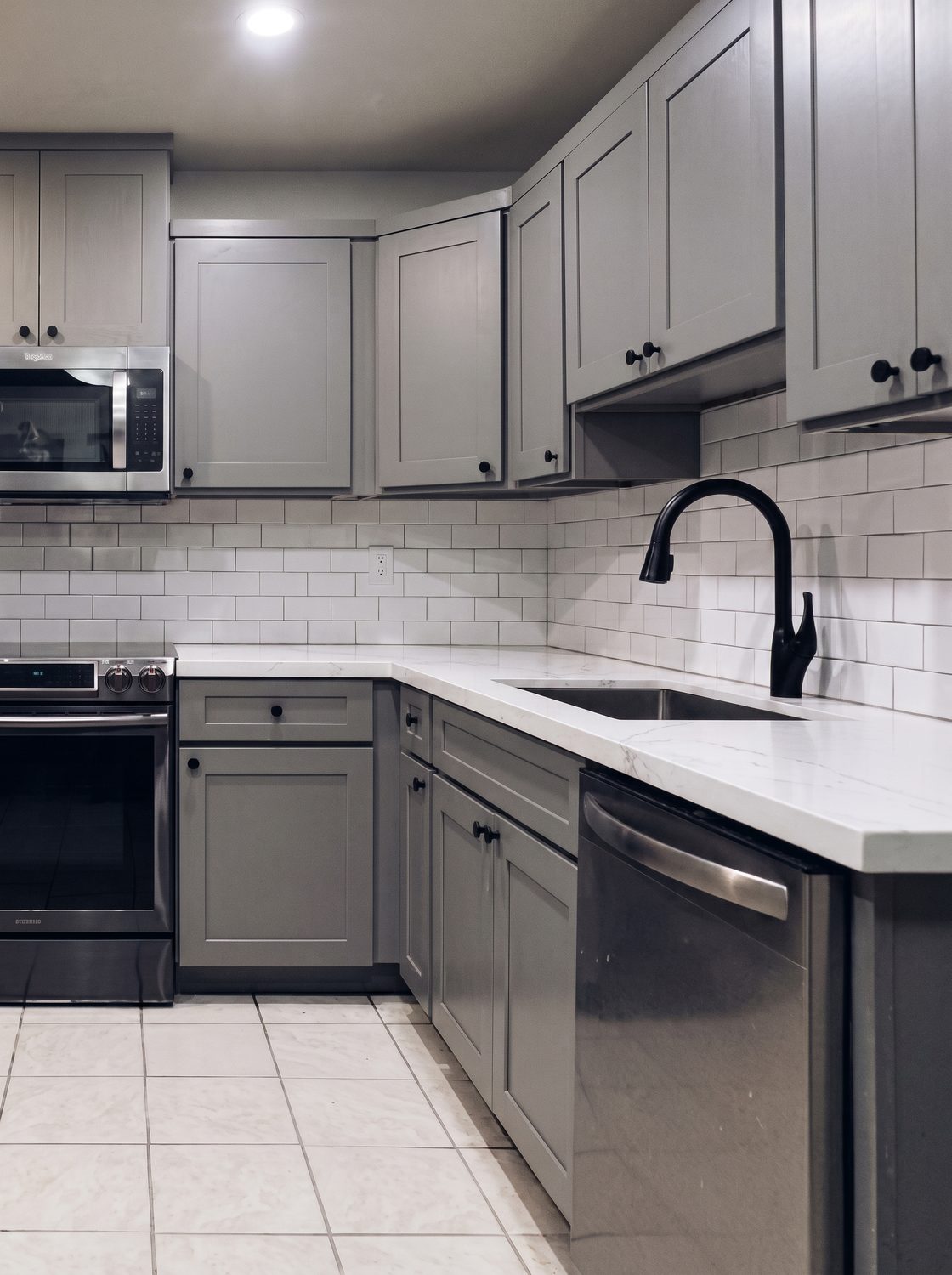 Graphite shaker kitchen with subway tile and a matte black faucet