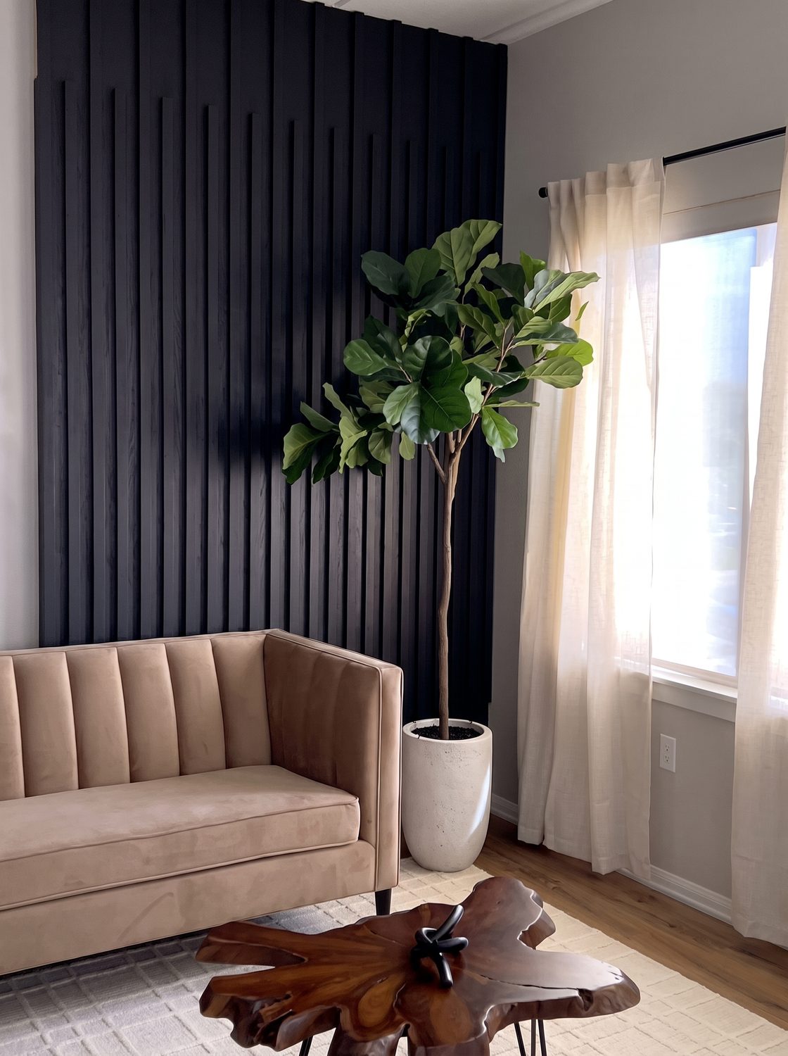 Slatted timber accent wall behind a low sofa and a live edge table