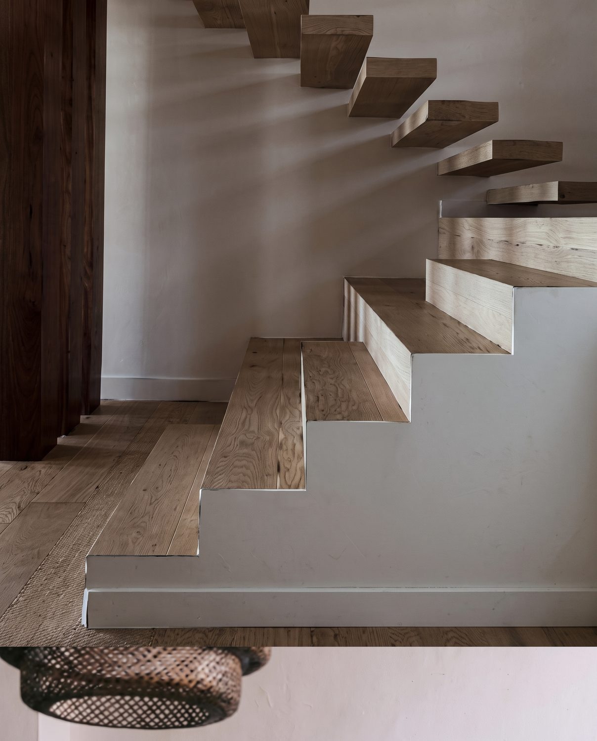 Floating timber staircase against smooth plaster walls